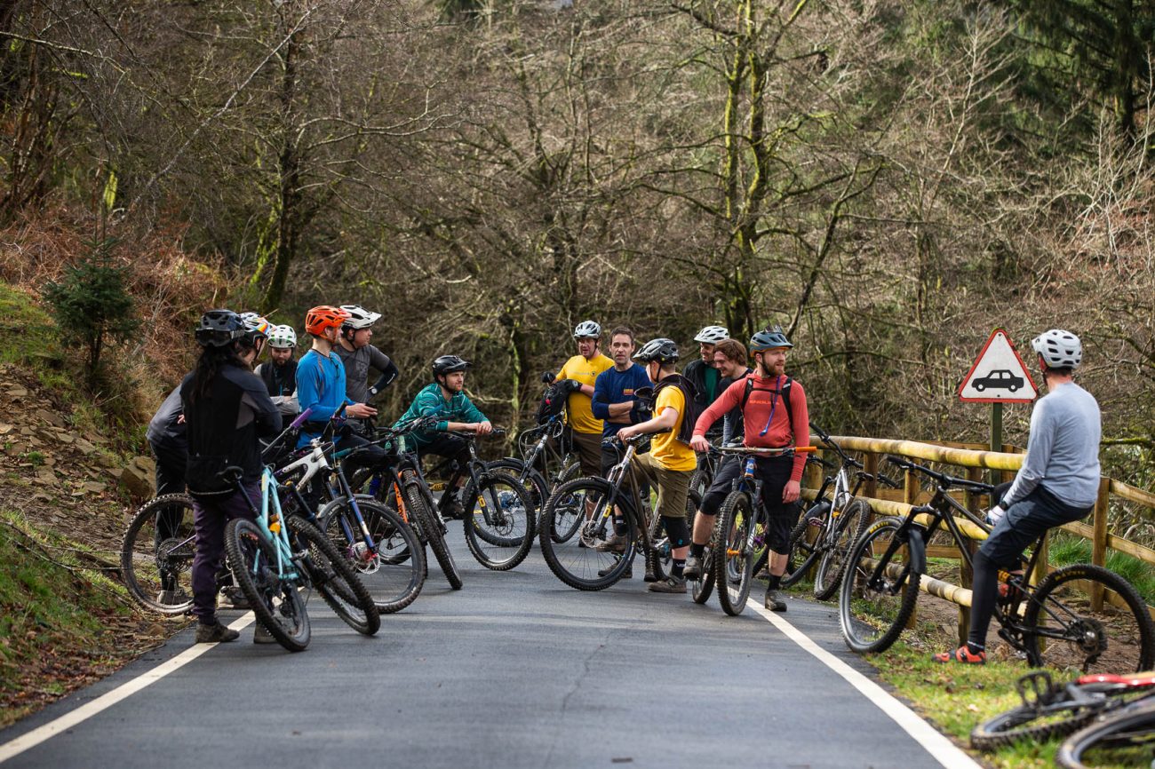 a group of riders chat at the top of a climb