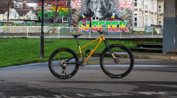 yellow mountain bike in a city setting with graffiti in background